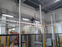 Mann installiert eine Beleuchtung in einer Produktionsstra&szlig;e