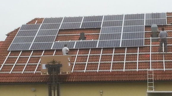 2-k&ouml;pfiges Team montiert auf einer Dachfl&auml;che PV-Module